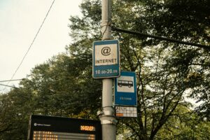 2 street signs above one another, one indicating internet with a time range, the other is a bus stop with the word Estonia