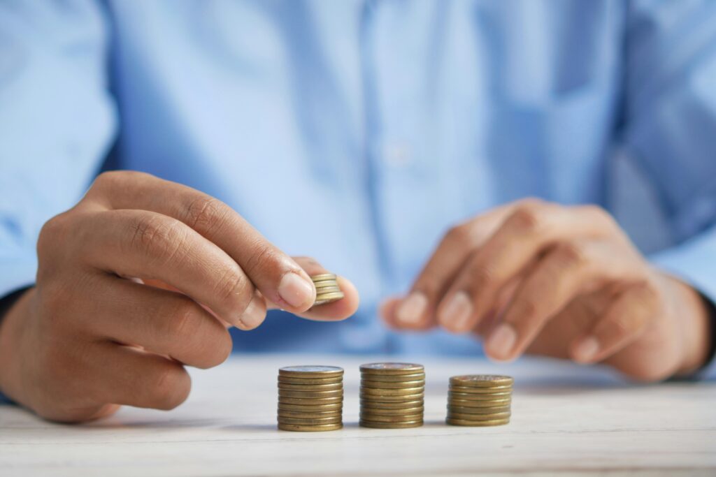 Hands stacking coins into 3 parts